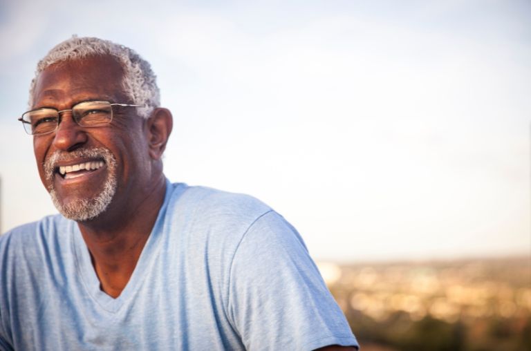 Old man with dentures smiling in Derby with glasses on