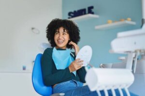 patient holding up mirror and smiling at dentist after fillings