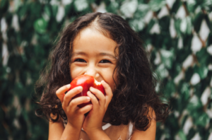 Young girl eating an apple after being taught dental health care using tips from Duffield Road